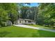 Angled view of home with long driveway and storage shed on a landscaped lawn at 4291 Lamar Street St, Decatur, GA 30035