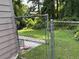 Backyard with weathered fence and green lawn, partially covered with vegetation at 8113 Fieldstream Way, Douglasville, GA 30134