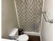Bathroom with toilet, shower, and neutral patterned shower curtain at 8113 Fieldstream Way, Douglasville, GA 30134