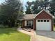 Charming brick home featuring a one-car garage and a well-manicured lawn at 8113 Fieldstream Way, Douglasville, GA 30134