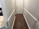 Hallway with white trim and neutral color walls and dark wood flooring at 8113 Fieldstream Way, Douglasville, GA 30134