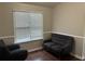Bright living room featuring a gray loveseat, armchair, and modern window at 8113 Fieldstream Way, Douglasville, GA 30134