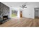 Spacious living room featuring a stone fireplace, hardwood floors, a ceiling fan, and natural light at 8212 Englewood Trl, Riverdale, GA 30274