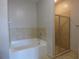 A bathroom featuring a bathtub with beige tile surround and a glass shower at 870 Mayson Turner Nw Rd # 1344, Atlanta, GA 30314