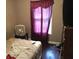 Bedroom with a twin bed, dresser, and a window covered by a maroon curtain at 1566 Avon Sw Ave, Atlanta, GA 30311