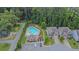 Aerial view of a community pool, clubhouse, homes, and a wooded area at 2638 Village Park Bnd, Duluth, GA 30096