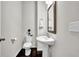 Cozy half-bathroom with a pedestal sink, modern fixtures, and dark wood-look flooring at 2638 Village Park Bnd, Duluth, GA 30096