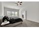 Bright bedroom features a ceiling fan, plush carpet, and large windows overlooking the landscaped yard at 2638 Village Park Bnd, Duluth, GA 30096