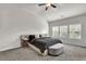 Bright bedroom features a ceiling fan, plush carpet, and large windows overlooking the landscaped yard at 2638 Village Park Bnd, Duluth, GA 30096