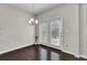 Dining room showcasing hardwood floors and glass doors with a modern light fixture at 2638 Village Park Bnd, Duluth, GA 30096