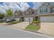 Street view of well-kept townhomes featuring attached garages and manicured front yards on a sunny day at 2638 Village Park Bnd, Duluth, GA 30096