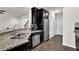 Stainless steel appliances and granite counters accent the dark wood cabinets in this kitchen at 2638 Village Park Bnd, Duluth, GA 30096