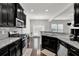Well-lit kitchen featuring stainless steel appliances, granite countertops, and dark cabinets at 2638 Village Park Bnd, Duluth, GA 30096