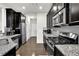 Modern kitchen with granite counters, stainless steel appliances, and dark wood cabinets at 2638 Village Park Bnd, Duluth, GA 30096