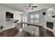Spacious open-concept living room with a fireplace, ceiling fan, bar seating and hardwood floors at 2638 Village Park Bnd, Duluth, GA 30096