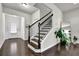 Elegant staircase with dark wood rails and a bright entryway with natural light at 2638 Village Park Bnd, Duluth, GA 30096