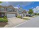 Street with attractive townhomes featuring brick accents, one-car garages, and manicured landscaping at 2638 Village Park Bnd, Duluth, GA 30096