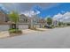 Street view of townhomes with brick accents, one-car garages, and manicured landscaping on a sunny day at 2638 Village Park Bnd, Duluth, GA 30096