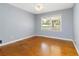 Bright bedroom featuring a ceiling fan, large window, and hardwood floors at 3999 Phils Ct, Tucker, GA 30084