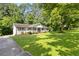 Well-maintained house with a lush front yard and a cozy porch, surrounded by mature trees at 3999 Phils Ct, Tucker, GA 30084