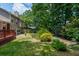 Lush backyard features a wooden deck, green lawn, and mature trees, offering privacy and space at 1115 Manor Nw Way, Kennesaw, GA 30144