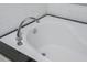 A bright white bathtub with chrome faucet fixture and tiled trim at 1115 Manor Nw Way, Kennesaw, GA 30144