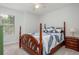 Bedroom with a four poster bed, side table, and a sunlit window with blinds at 1115 Manor Nw Way, Kennesaw, GA 30144