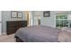 A bedroom featuring a modern dresser, light blue walls, and natural light from two windows at 1115 Manor Nw Way, Kennesaw, GA 30144