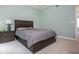 Bedroom with neutral walls and carpet, showcasing a bed with a dark wood frame and a bedside table at 1115 Manor Nw Way, Kennesaw, GA 30144