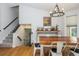 A bright dining area next to carpeted stairs offers hardwood floors, a modern chandelier, and a charming bar table at 1115 Manor Nw Way, Kennesaw, GA 30144