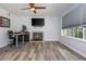 Cozy living room with a fireplace, ceiling fan, and large window at 1115 Manor Nw Way, Kennesaw, GA 30144