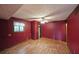 Bedroom with hardwood floors, window, ceiling fan, closet, and a fresh coat of red paint at 3038 Skidaway Ct, Stone Mountain, GA 30087