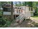 Charming white two-story home featuring a spacious front deck and stone accents, surrounded by lush trees at 3038 Skidaway Ct, Stone Mountain, GA 30087