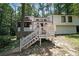 Charming white two-story home featuring a spacious front deck and stone accents, surrounded by lush trees at 3038 Skidaway Ct, Stone Mountain, GA 30087