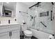 Bathroom with white marbled tile, black finishes, and modern glass shower at 1280 W Peachtree W St, Atlanta, GA 30309
