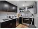 Galley kitchen with stainless steel appliances, modern backsplash, and sleek dark cabinetry at 1280 W Peachtree W St, Atlanta, GA 30309