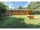 Lush backyard with a brick home, patio cover, and green lawn at 5670 Lanny Dr, Powder Springs, GA 30127