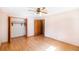 Bright bedroom featuring a ceiling fan, closet, and original hardwood flooring throughout at 5670 Lanny Dr, Powder Springs, GA 30127