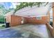 Brick carport featuring an outdoor ceiling, white door, and open parking space at 5670 Lanny Dr, Powder Springs, GA 30127