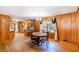 Dining room with hardwood floors and wooden paneled walls flows into kitchen at 5670 Lanny Dr, Powder Springs, GA 30127