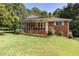 Charming brick home with a screened-in porch and mature landscaping at 5670 Lanny Dr, Powder Springs, GA 30127