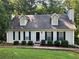 Charming home featuring a light-colored exterior, dark shutters, dormer windows, and a well-maintained lawn at 1005 Timbervale Ln, Lithonia, GA 30058