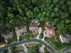 Stunning aerial view of the luxury home nestled among mature trees with backyard pools at 5507 Aviemore Ct, Suwanee, GA 30024