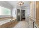 Elegant bathroom with a soaking tub, tiled floors, granite countertop, and white cabinets at 5507 Aviemore Ct, Suwanee, GA 30024