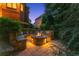 Stone fire pit with seating and lush landscaping creates a cozy outdoor gathering space at 5507 Aviemore Ct, Suwanee, GA 30024