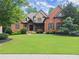 Charming two-story brick home with a well-manicured lawn and mature trees at 5507 Aviemore Ct, Suwanee, GA 30024
