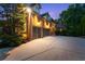 Three car garage with brick exterior and a wide driveway complemented by mature landscaping at 5507 Aviemore Ct, Suwanee, GA 30024