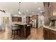 Open kitchen featuring dark wood cabinets, granite countertops, stainless steel appliances, and an island with seating at 5507 Aviemore Ct, Suwanee, GA 30024
