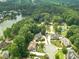 Aerial view showcasing a neighborhood with mature trees, a lake, and well-manicured lawns at 1432 Arbor Bluff Ct, Lawrenceville, GA 30045