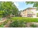 Large, green backyard features a covered deck, stone patio, mature trees, and lush landscaping at 1432 Arbor Bluff Ct, Lawrenceville, GA 30045